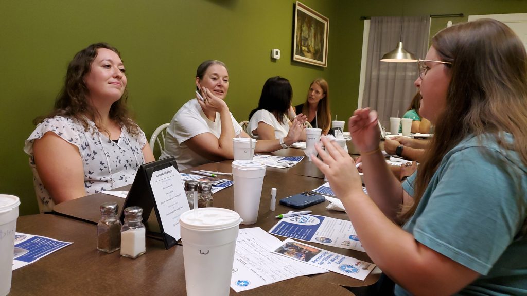 People sitting around a table eating dinner at a restaurant 